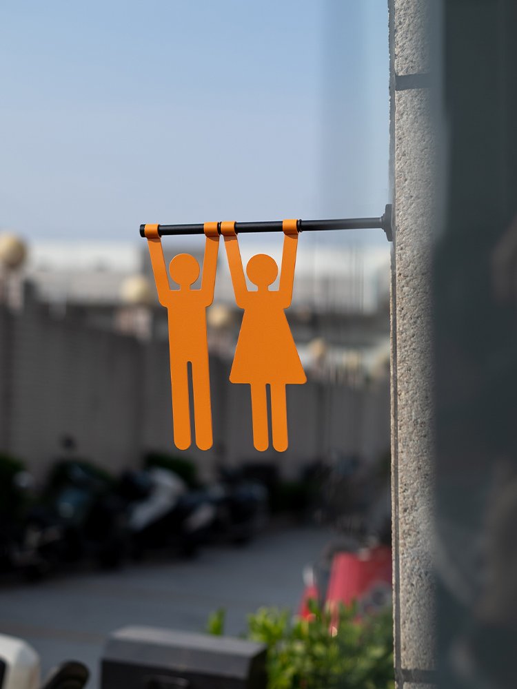 Hanging metal restroom sign mounted perpendicular to a wall